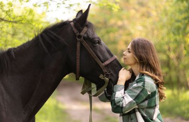 Frau streichelt ein Pferd